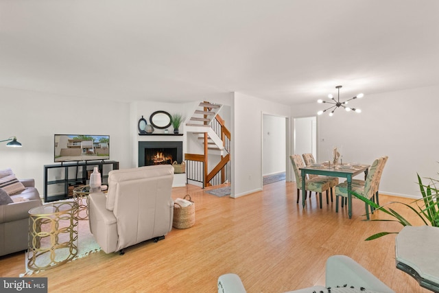 11645 Newbridge Ct, Reston, VA 20191 - living area with wood finished floors, a chandelier, stairs, a lit fireplace, and baseboards