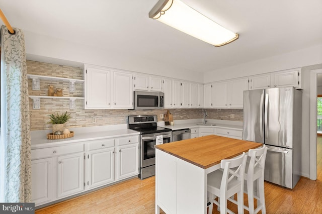 11645 Newbridge Ct, Reston, VA 20191 - kitchen featuring appliances with stainless steel finishes, a sink, white cabinetry, and tasteful backsplash