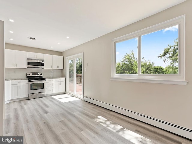 14 Featherbed Ln, Norristown, PA 19403 - kitchen featuring baseboard heating, white cabinets, light wood finished floors, appliances with stainless steel finishes, and backsplash