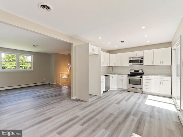 14 Featherbed Ln, Norristown, PA 19403 - kitchen with visible vents, light wood-type flooring, a baseboard heating unit, stainless steel appliances, and white cabinetry