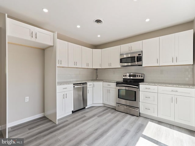 14 Featherbed Ln, Norristown, PA 19403 - kitchen featuring visible vents, white cabinetry, light stone countertops, and stainless steel appliances