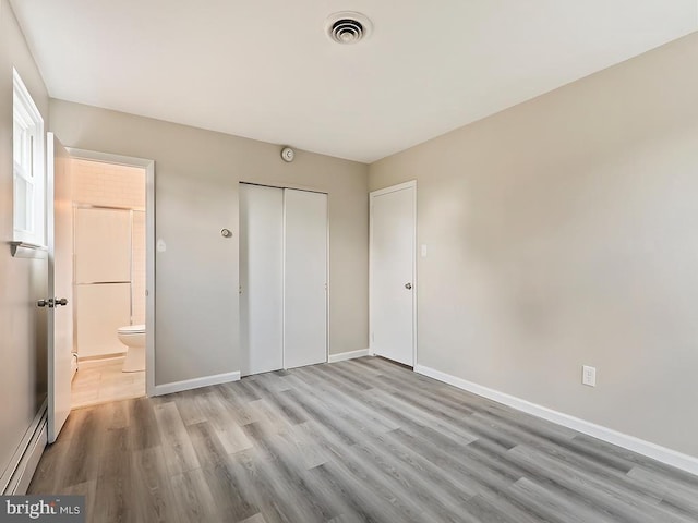 14 Featherbed Ln, Norristown, PA 19403 - unfurnished bedroom featuring visible vents, wood finished floors, baseboards, a closet, and a baseboard heating unit