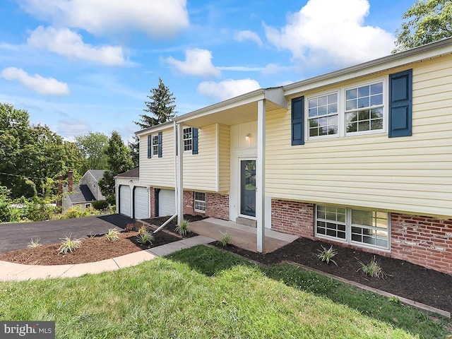 14 Featherbed Ln, Norristown, PA 19403 - split foyer home featuring an attached garage, a front yard, driveway, and brick siding