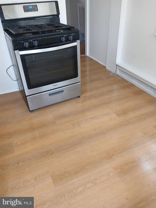 details featuring light wood finished floors and stainless steel gas range oven