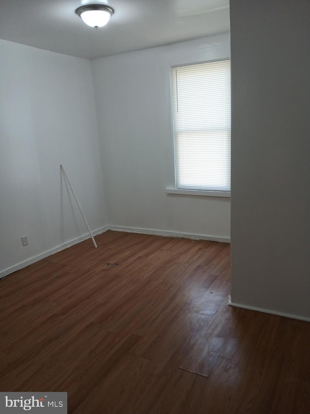 empty room featuring baseboards and wood finished floors