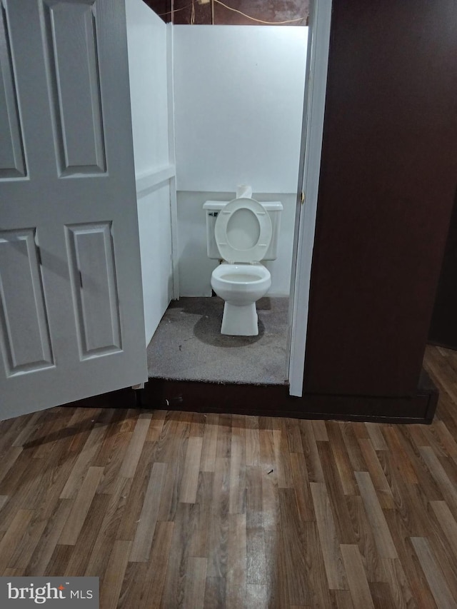 bathroom with toilet and wood finished floors