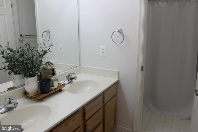 bathroom with double vanity, tile patterned floors, and a sink