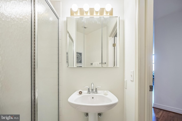 full bath with a sink and wood finished floors