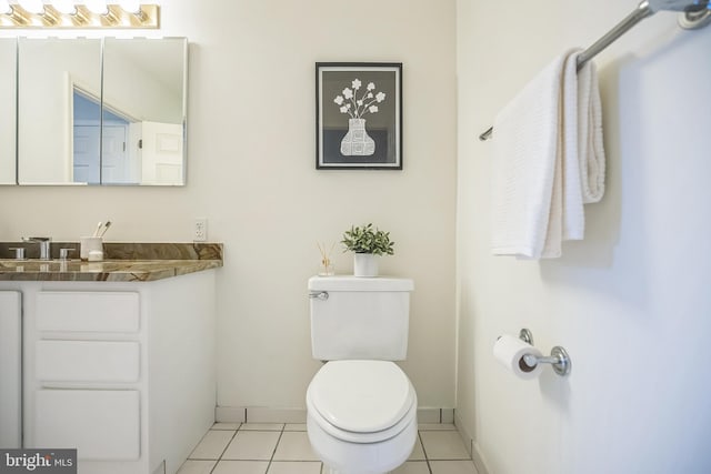 bathroom with tile patterned floors, baseboards, vanity, and toilet