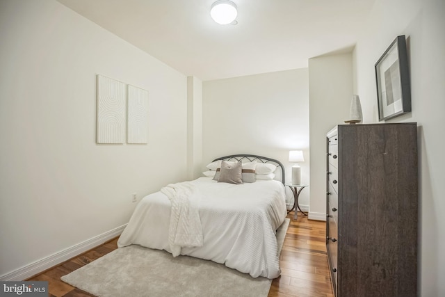 bedroom featuring baseboards and wood finished floors