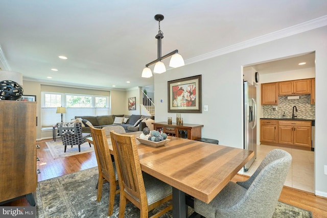 dining space with crown molding, baseboards, stairway, recessed lighting, and light wood-type flooring