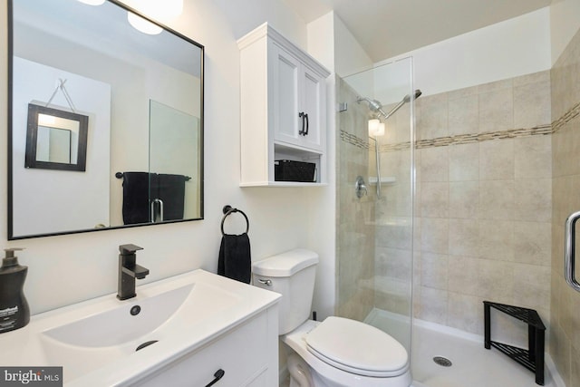full bath with vanity, a stall shower, and toilet