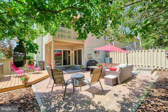 view of patio featuring a deck, fence, a balcony, an outdoor hangout area, and a grill