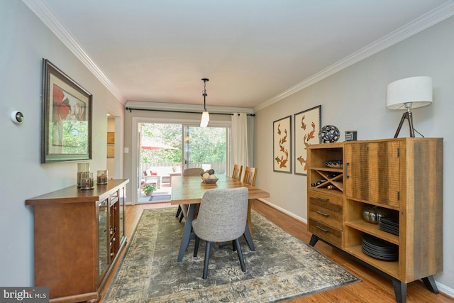 dining room featuring baseboards, ornamental molding, and wood finished floors