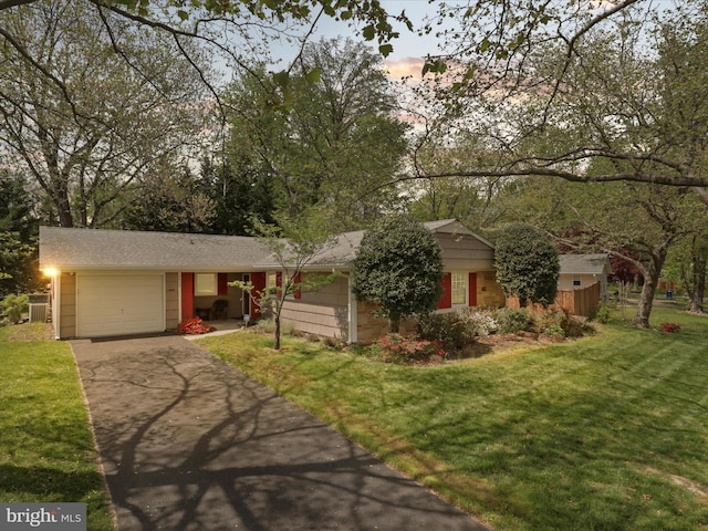 single story home featuring an attached garage, driveway, and a front yard