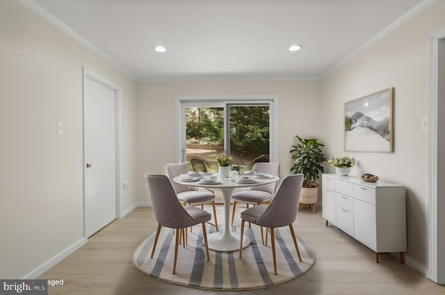 dining room with baseboards, ornamental molding, and light wood finished floors