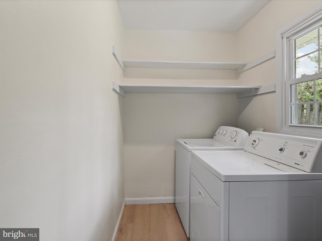 laundry area with baseboards, laundry area, light wood finished floors, and washing machine and clothes dryer