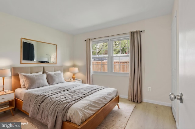 bedroom with baseboards and light wood finished floors