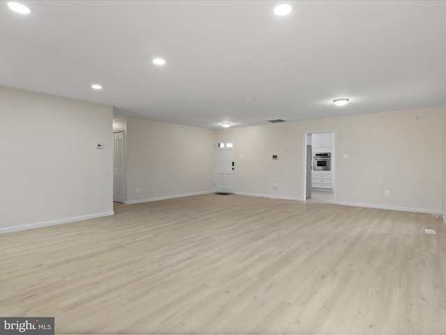 unfurnished living room with light wood-style floors, baseboards, recessed lighting, and visible vents