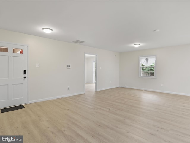 spare room with baseboards, visible vents, and light wood-style flooring