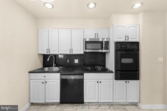 kitchen featuring a sink, dark countertops, white cabinets, black appliances, and a warming drawer