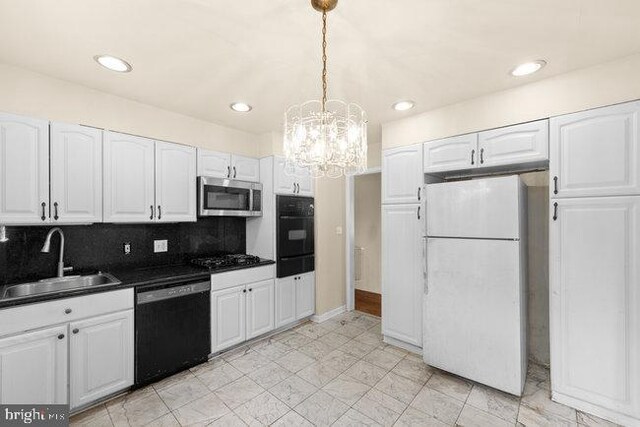 kitchen featuring a sink, dark countertops, white cabinets, black appliances, and a warming drawer