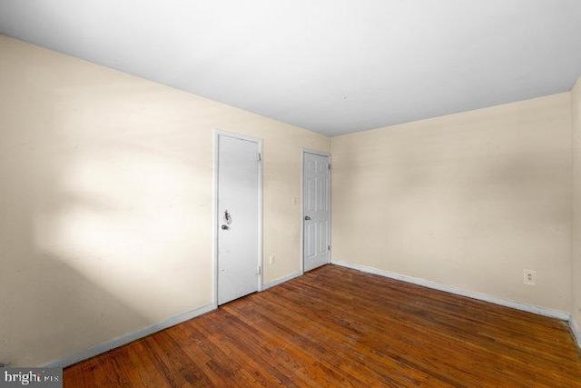 unfurnished room featuring baseboards and wood finished floors