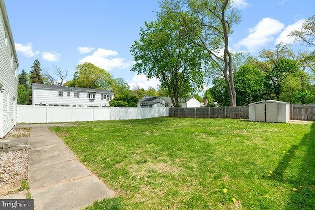 view of yard featuring a fenced backyard, a storage shed, and an outdoor structure