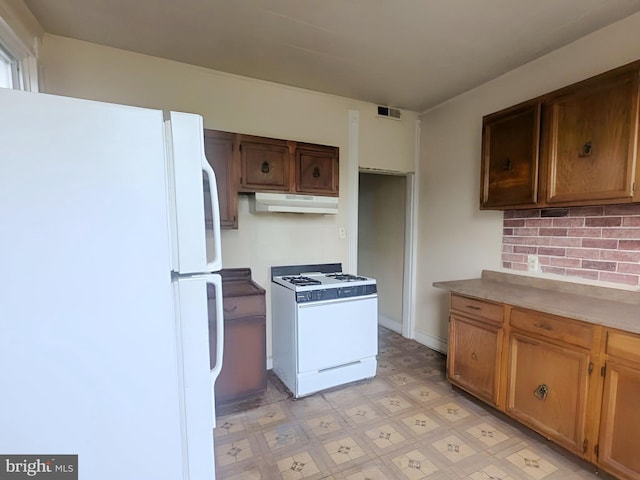 kitchen with visible vents, light countertops, light floors, under cabinet range hood, and white appliances