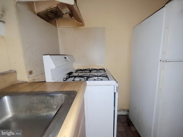 kitchen featuring white appliances and a sink