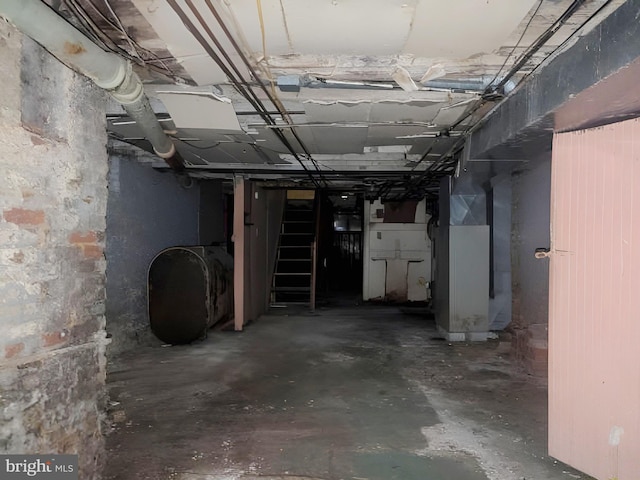 unfinished below grade area with heating unit, heating fuel, and stairs