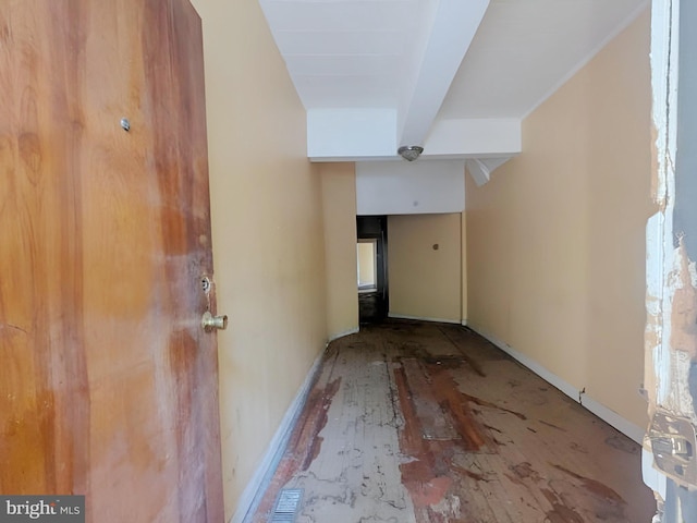 hall featuring baseboards and beam ceiling