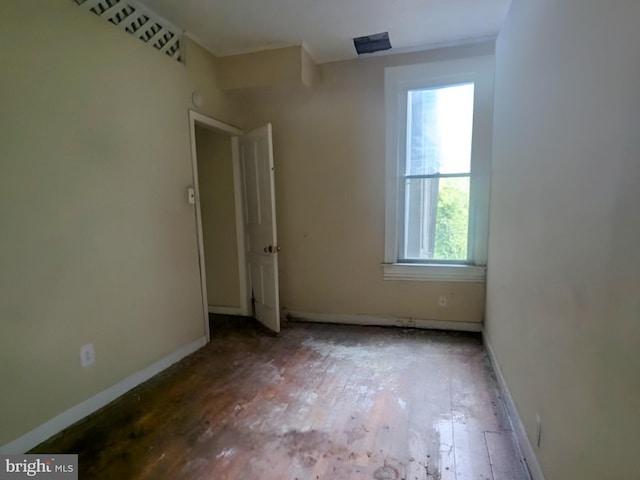 empty room with baseboards and hardwood / wood-style flooring