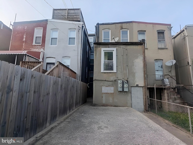 back of property with fence and stucco siding