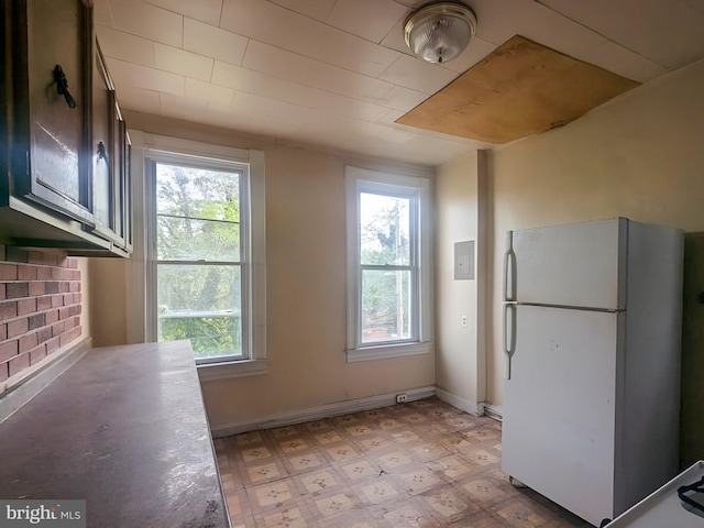 unfurnished dining area featuring baseboards, light floors, and a wealth of natural light