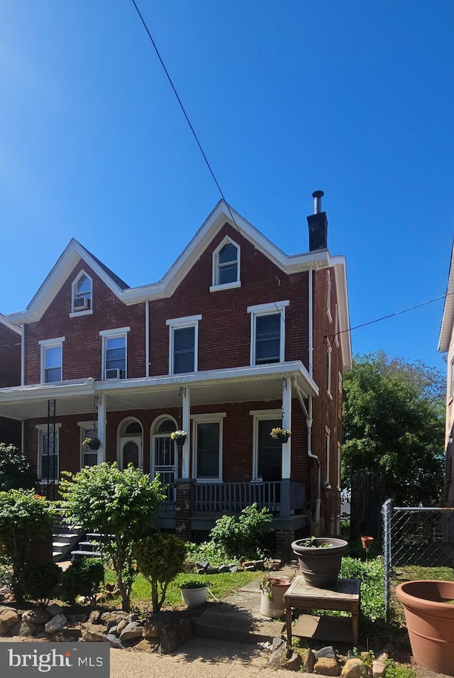 1110 W Sixth St, Wilmington, DE 19805 - view of front of property featuring a porch, brick siding, and fence