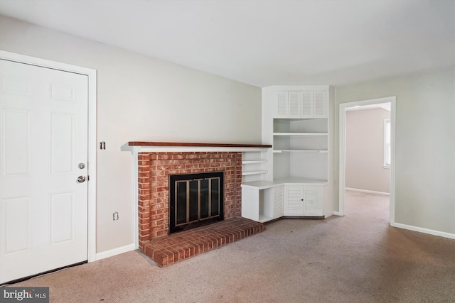 unfurnished living room featuring a brick fireplace, baseboards, and carpet floors