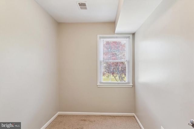 spare room featuring carpet flooring, baseboards, and visible vents