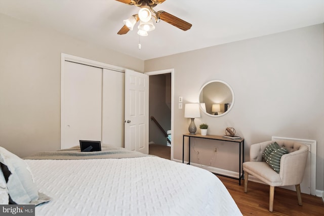 bedroom with a ceiling fan, baseboards, wood finished floors, and a closet