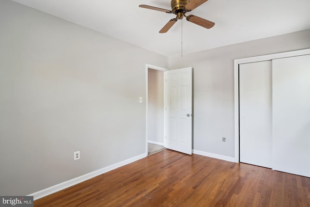 unfurnished bedroom with baseboards, a ceiling fan, a closet, and wood finished floors