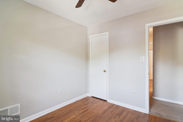 unfurnished bedroom with visible vents, baseboards, ceiling fan, and wood finished floors