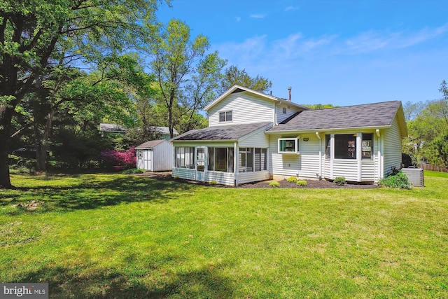back of property with roof with shingles, a sunroom, an outdoor structure, a storage unit, and a yard