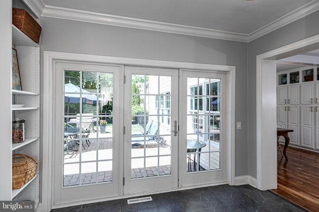 doorway featuring baseboards, visible vents, and ornamental molding