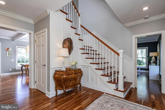 staircase featuring crown molding, a healthy amount of sunlight, and wood finished floors