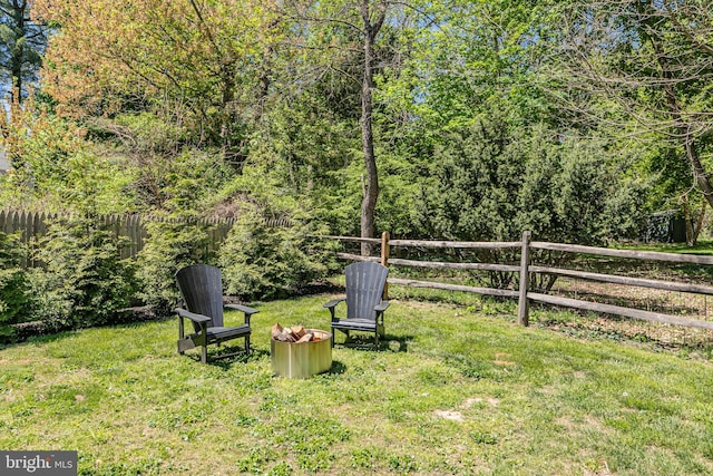view of yard with an outdoor fire pit and fence