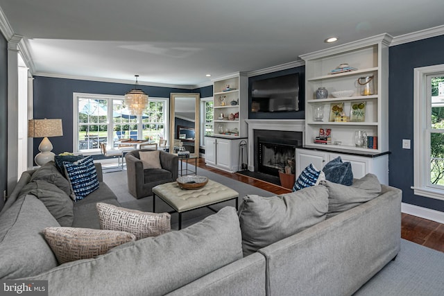 living area featuring crown molding, dark wood-style flooring, a large fireplace, recessed lighting, and baseboards