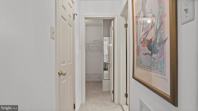 hallway featuring light colored carpet