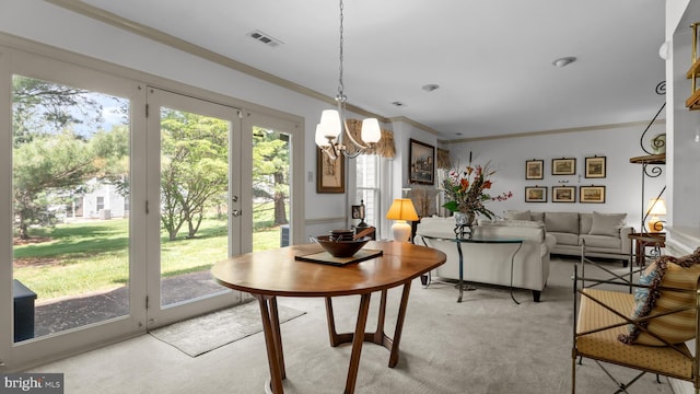 dining room with plenty of natural light, visible vents, ornamental molding, and a notable chandelier