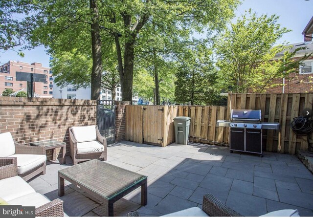 view of patio / terrace featuring fence, an outdoor living space, and a grill