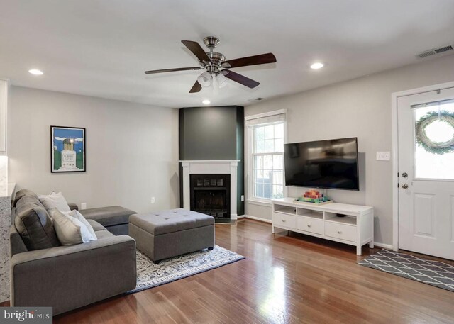 living room featuring visible vents, wood finished floors, ceiling fan, recessed lighting, and a fireplace with flush hearth